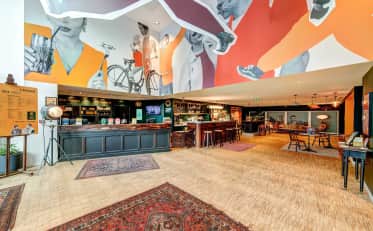 Moderna hall e reception dell'hotel B&B HOME con murales artistici e accoglienti aree salotto