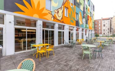 Colorata terrazza esterna presso B&B HOME con vivace murale e moderni posti a sedere in stile bistrot per gli ospiti