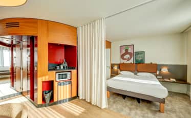 Modern hotel room at B&B HOME featuring a kitchenette with microwave and a comfortable double bed with artistic decor