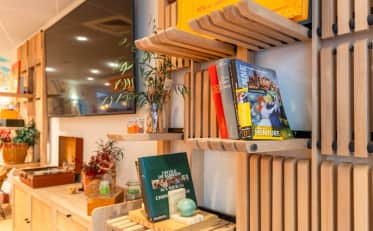 Modernes Holzregal mit Kunstbüchern und Dekoration in der gemütlichen Lobby von B&B HOME