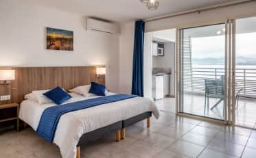 Modern B&B HOME studio apartment with king bed kitchenette and balcony overlooking the sea