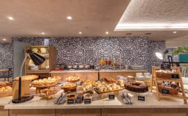 Delicious breakfast buffet at B&B HOTEL featuring fresh pastries cakes and spreads in a modern dining area