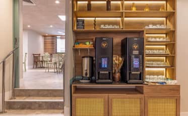Modern coffee station with professional machines and glassware at B&B HOTEL breakfast area