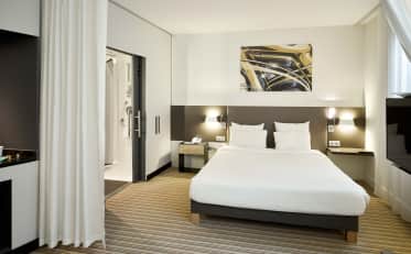 Camera d'albergo moderna presso B&B HOME con comodo letto matrimoniale e bagno a vista con doccia walk-in