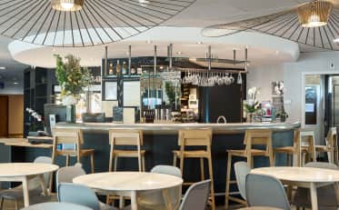 Moderna area bar dell'hotel con sgabelli in legno e illuminazione elegante presso B&B HOME