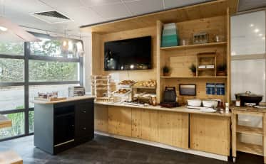 Area colazione presso B&B HOME con pasticcini e pane fresco in un moderno ambiente in legno
