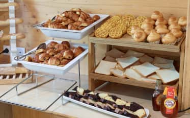 Buffet della colazione fresco con pasticcini e pane presso l'hotel B&B HOME