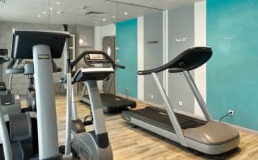 Moderno centro fitness dell'hotel B&B HOME con tapis roulant e attrezzature cardio professionali Technogym