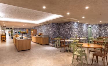 Modern breakfast area at B&B HOTEL with buffet station and stylish seating in a contemporary dining room