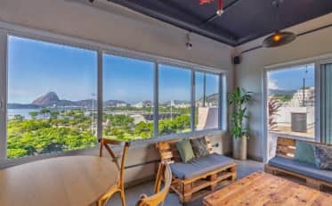 Modern B&B HOTEL lounge area with pallet furniture and panoramic bay view of Rio de Janeiro