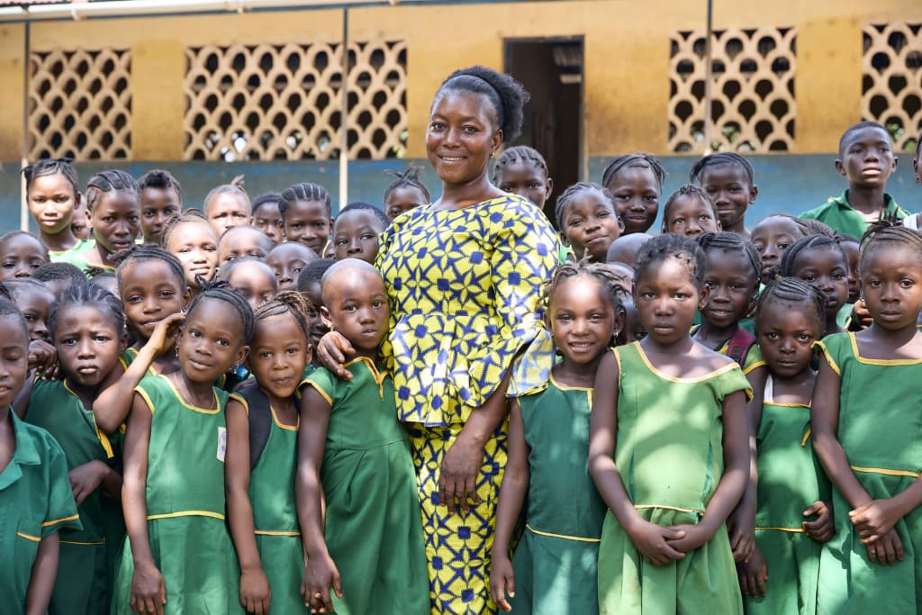 Teacher with a number of students at Mabinty Patricial Thullay School 