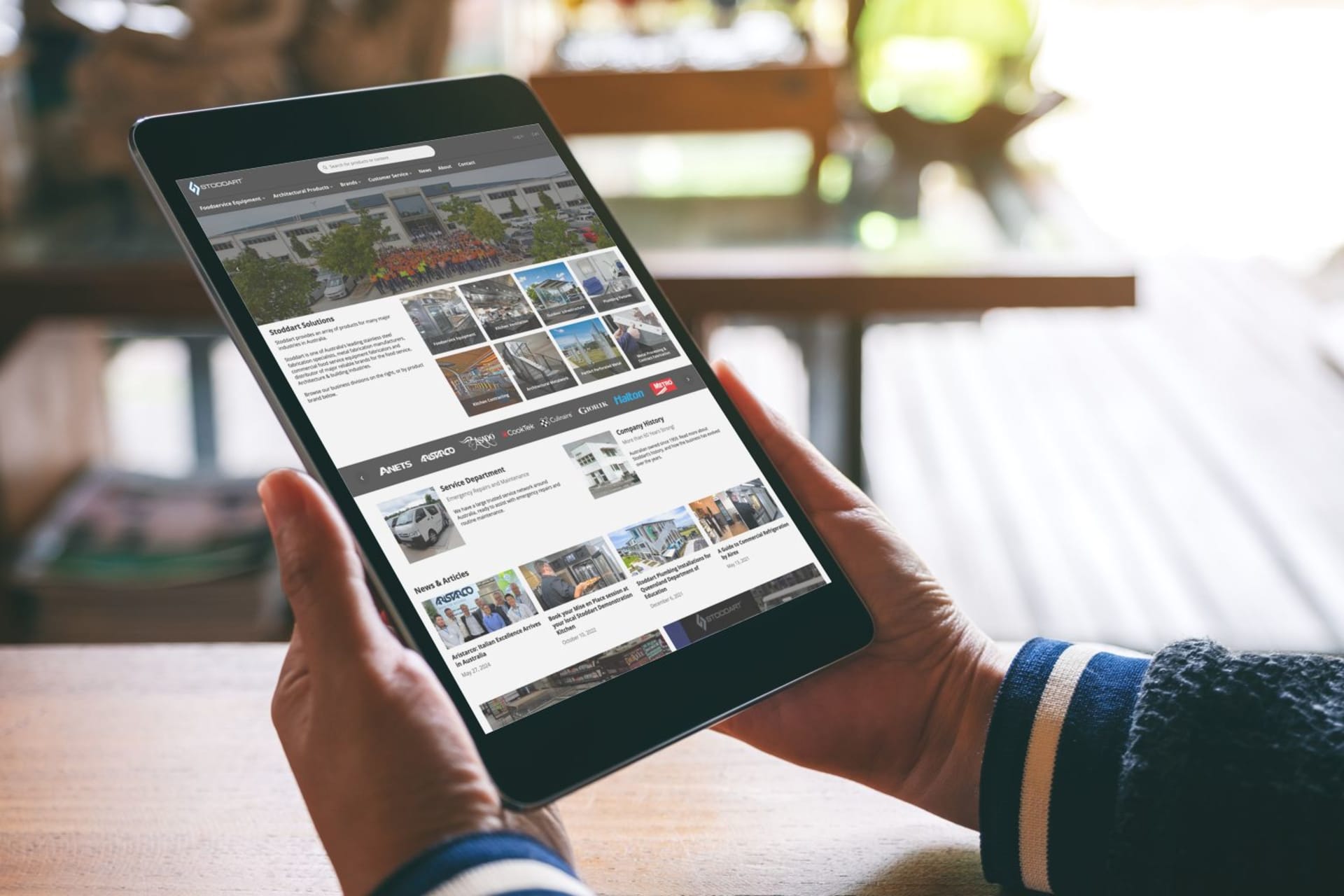 Tablet displaying Stoddart Website being held in hands