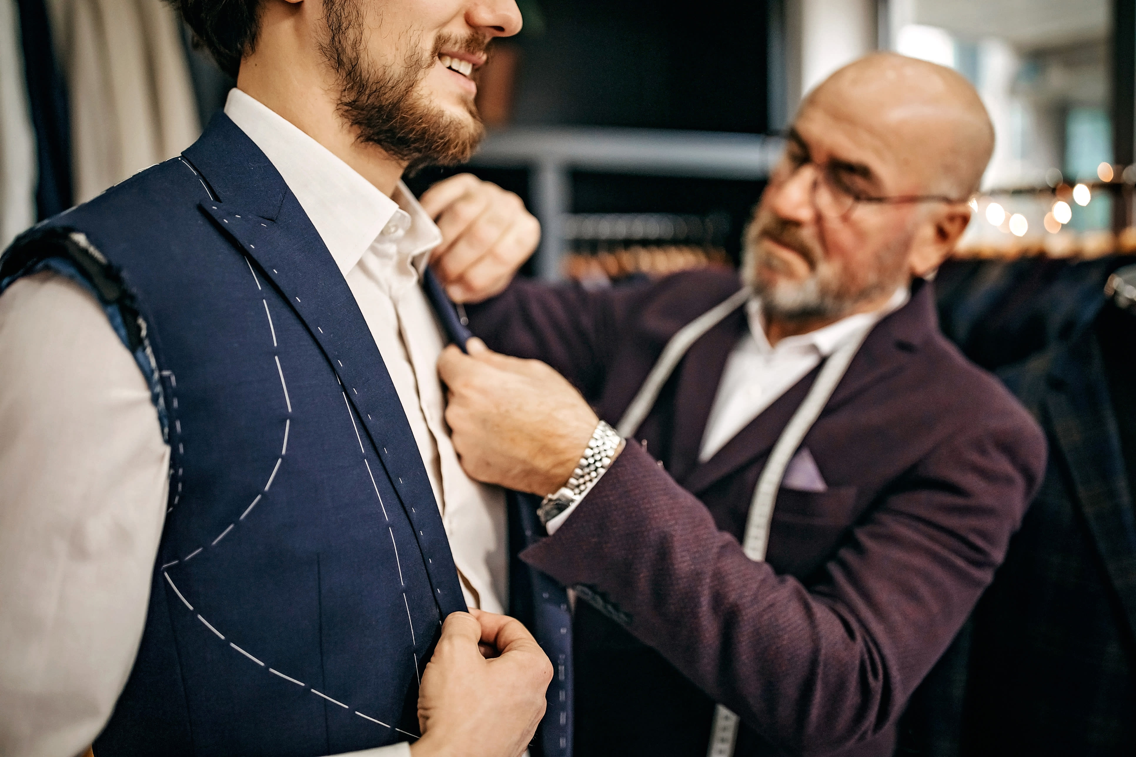 Tailor adjusting half made bespoke jacket