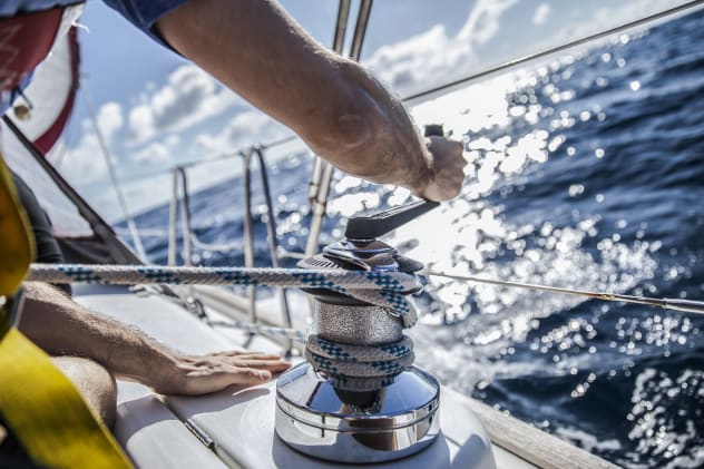 Man winding rope on a sail boat