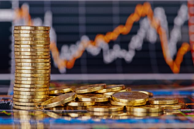 Gold coins in front of finance charts