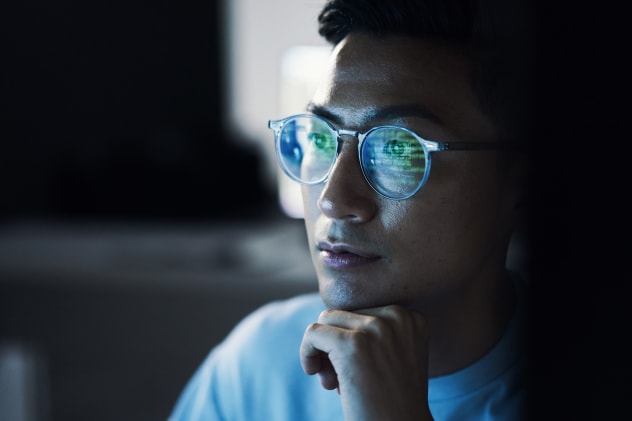 Computer code reflected in man's glasses