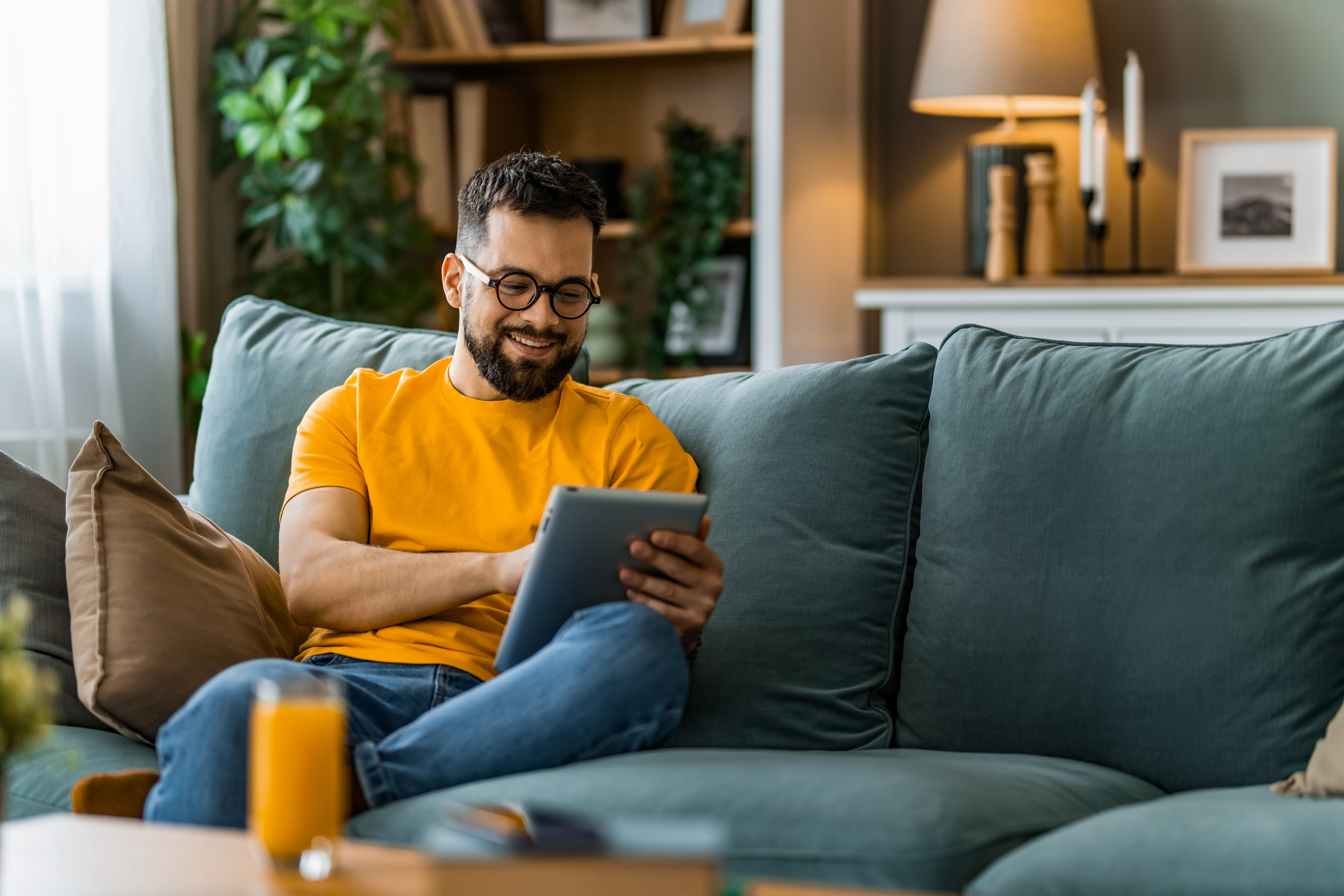 Man relaxing on couch using tablet