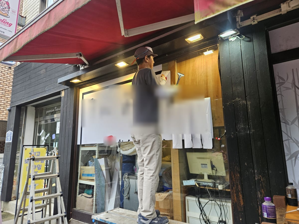 외벽 메뉴 보드의 글씨를 지워내는 작업
