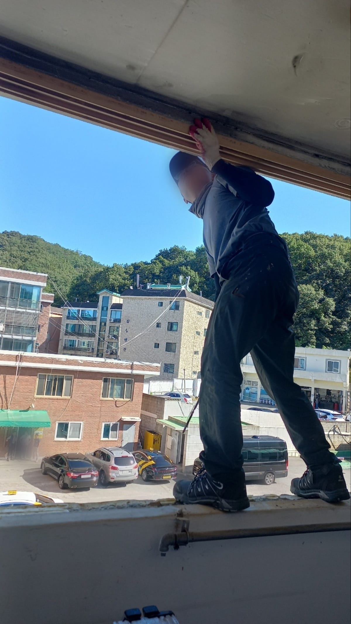 뒤틀린 옛 목재 창틀을 뜯어내는 샷시 철거 작업