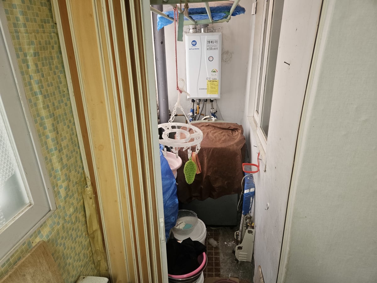 보일러실 가스보일러 아래 천으로 덮여 있던 세탁기와 양동이, 빨래걸이