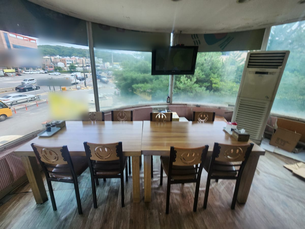 창가 끝자리에 놓여 있던 테이블과 의자, 스탠드 에어컨, 벽걸이 TV