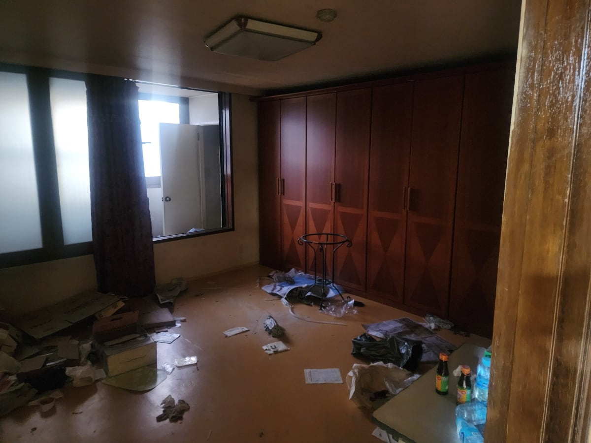 붙박이장 앞 바닥에 흩어진 빈 병과 생활 쓰레기