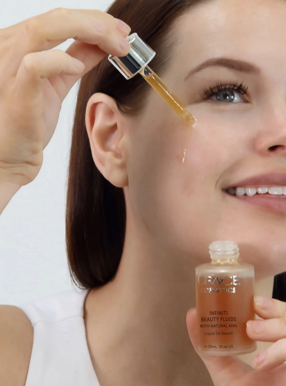 Person applying Infiniti Beauty Fluids onto face