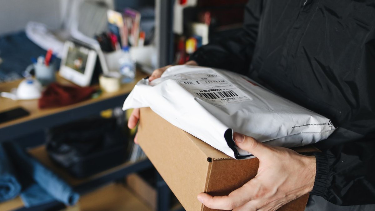 China’s leading beverage packaging machine manufacturers Close-up of hands holding cardboard and plastic packages, symbolizing delivery and shipping.