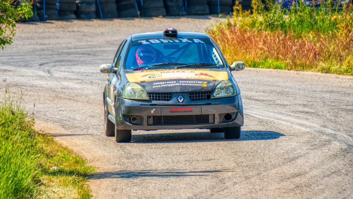 Thrilling car race along a winding track in Ritsona, Greece, showcasing speed and excitement.