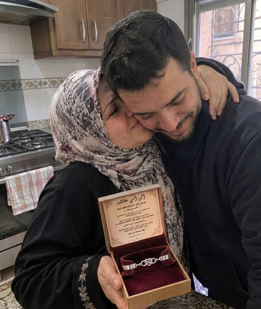 ابن يحتضن أمه بعد أن أهداها السوار مع الرسالة