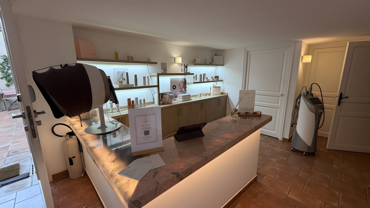 L'accueil du centre de soins Fleurs de Coton à La Ferme d'Augustin, comptoir en marbre et étagères de cosmétiques