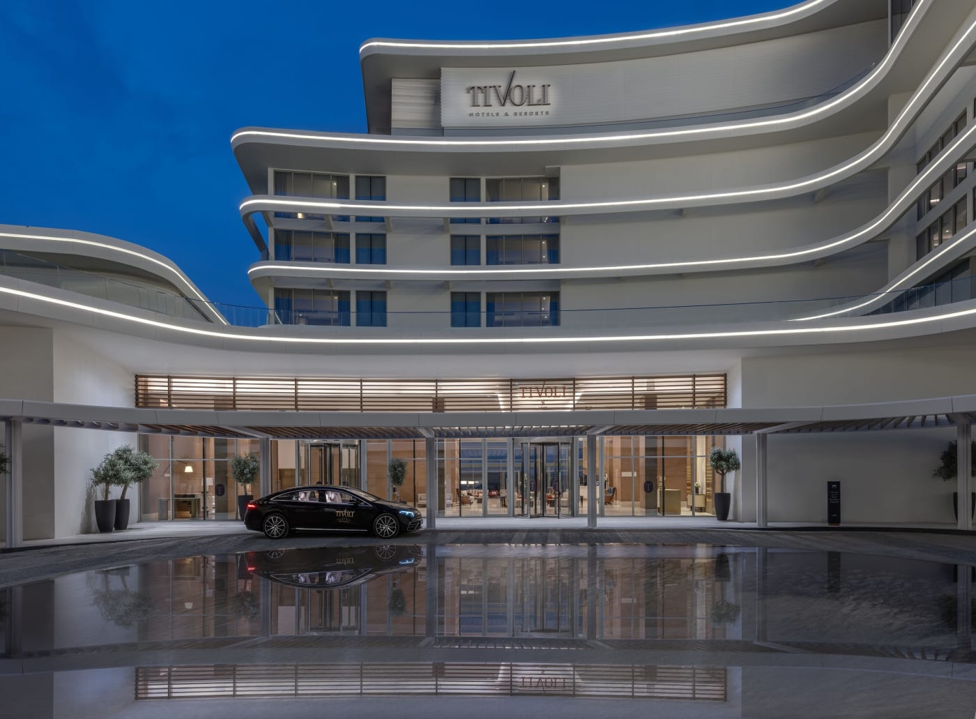 Entrada do Tivoli LA VIE Muscat Hotel & Residences à noite, com seu espelho d'água
