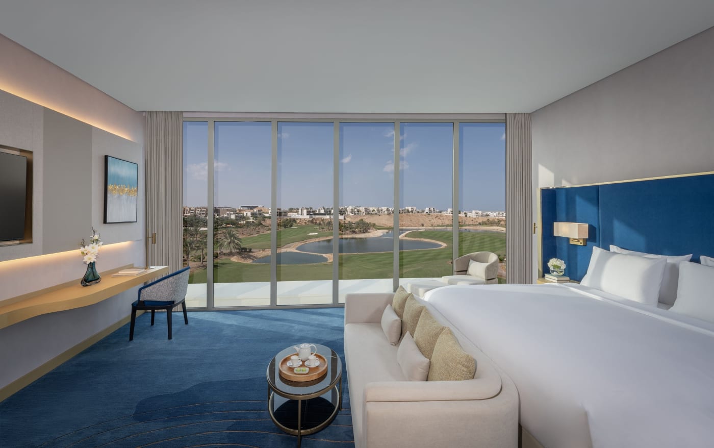 Junior Golf View Suite do Tivoli LA VIE Muscat, com janelão aberto para o golfe
