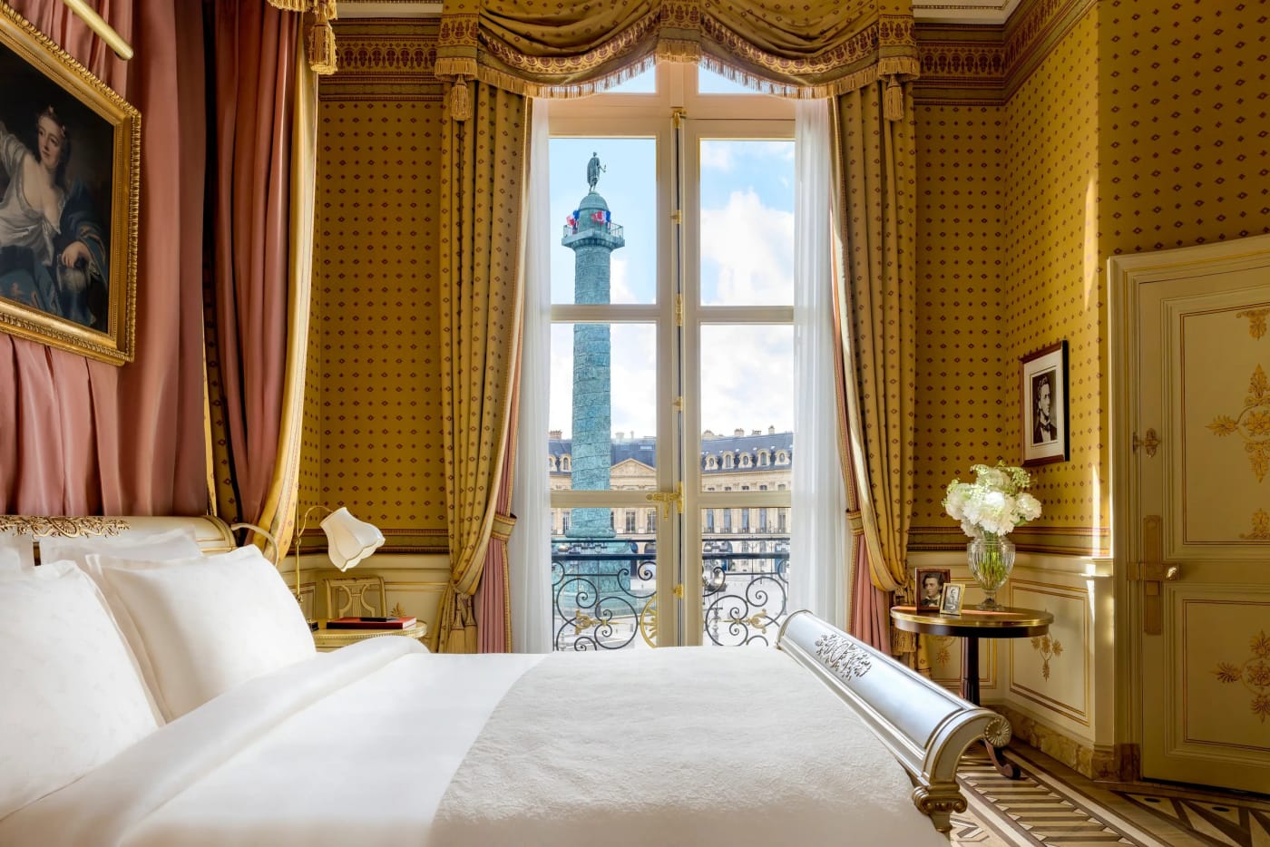 Une chambre du Ritz Paris, tentures dorées et fenêtre ouverte sur la colonne de la place Vendôme