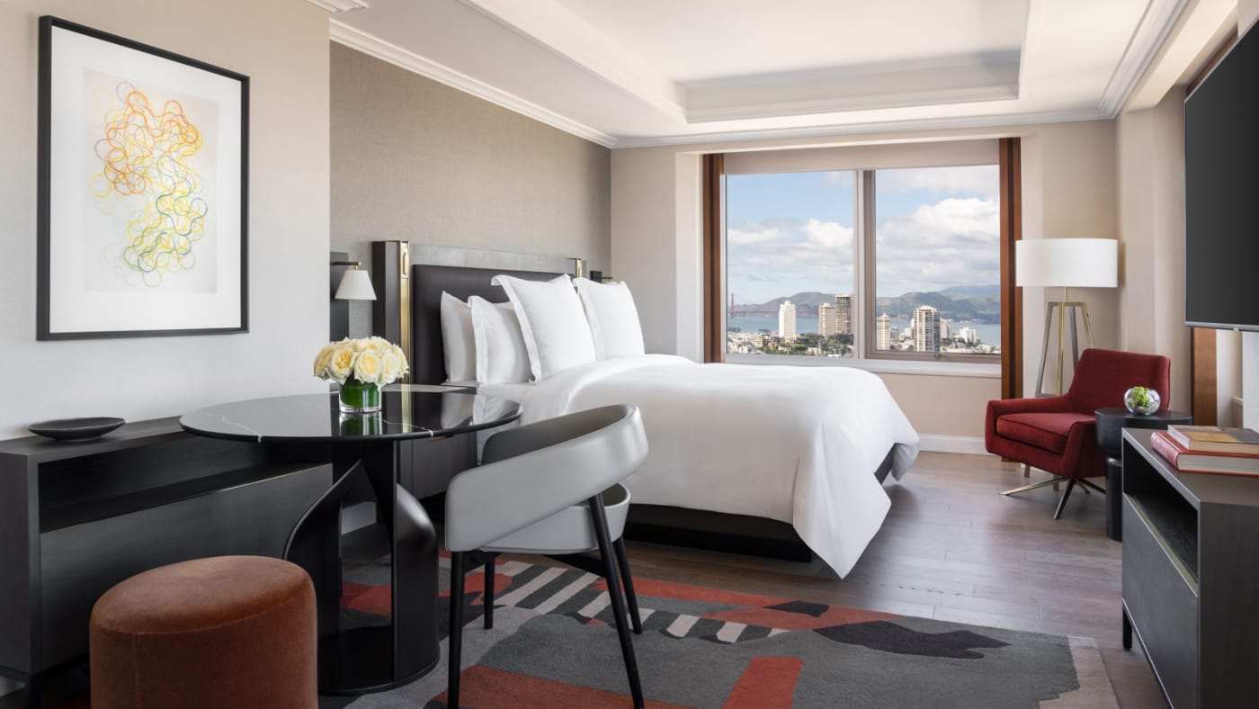 Landmark Suite bedroom at the Four Seasons Embarcadero, king-size bed facing a window that frames the Golden Gate Bridge