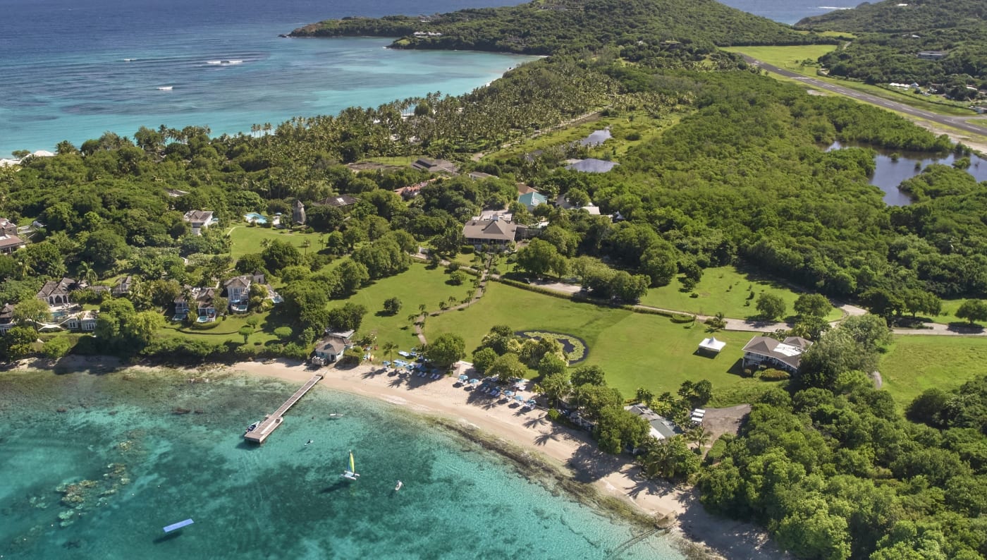 Vista aérea da ilha de Mustique e da baía de Endeavour, onde fica o The Cotton House