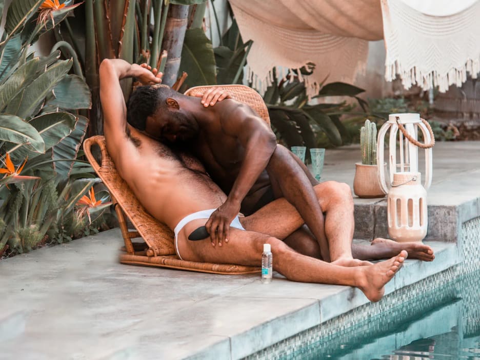 Two men caressing each other by a pool