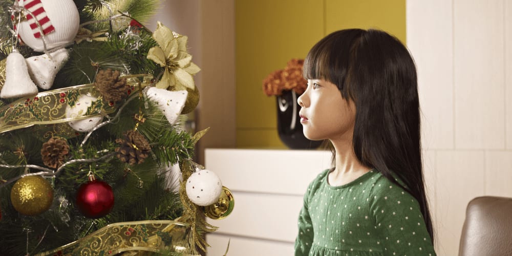 Chinese girl looking at Christmas tree