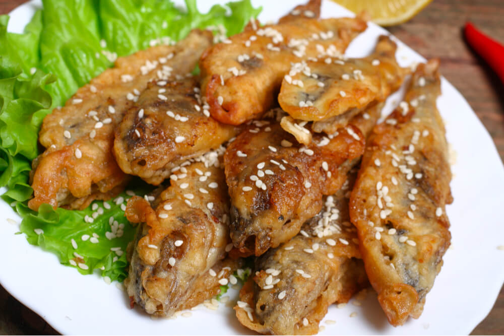 A plate of boquerones sprinkled with sesame seeds.