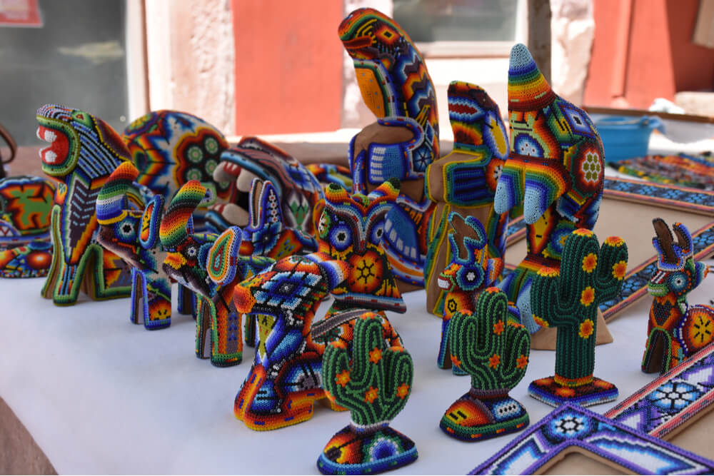 Huichol art includes yarn paintings and symbolic objects decorated with beads