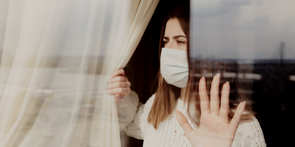 Woman in a mask by a window