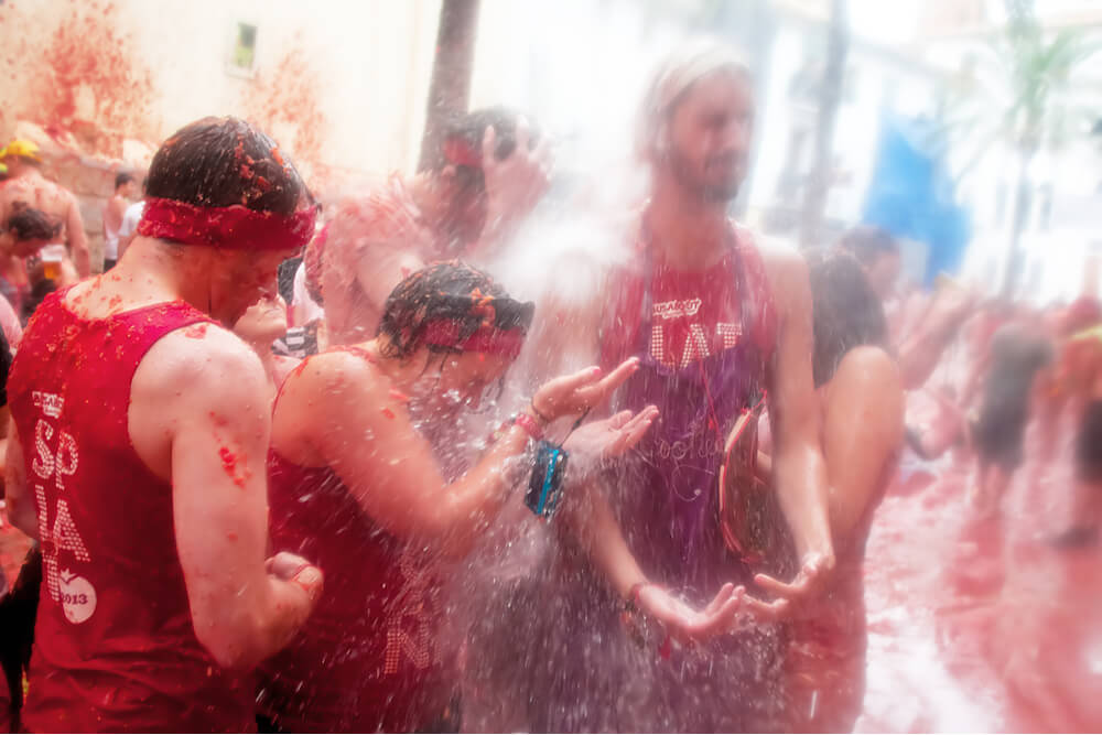 After the tomato battle, firefighters wash the streets and participants down with hoses