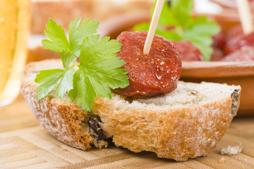 Chorizo a la Sidra - Spanish spicy chorizo sausages cooked in cider on top of crusty bread