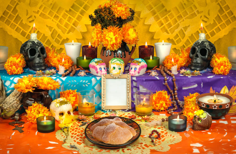 Traditional mexican Day of the dead altar with pan de muerto and candles