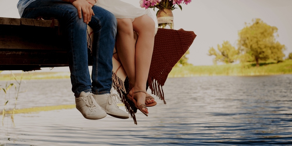 Legs of romantic couple near a lake