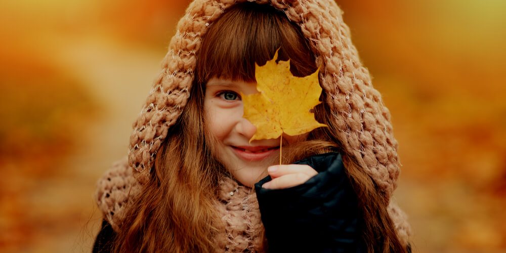 Small girl with an autumn leaf