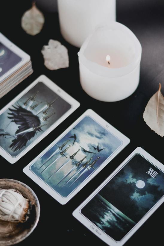 three card tarot spread with white candles
