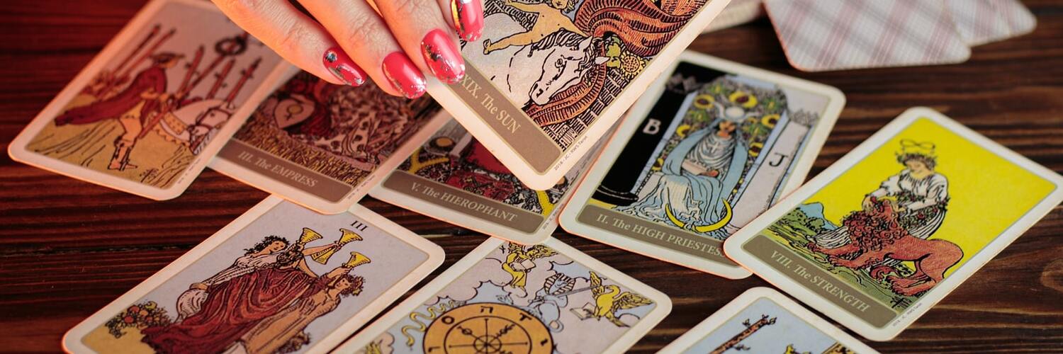 A tarot reading in progress, where cards are laid across a table.