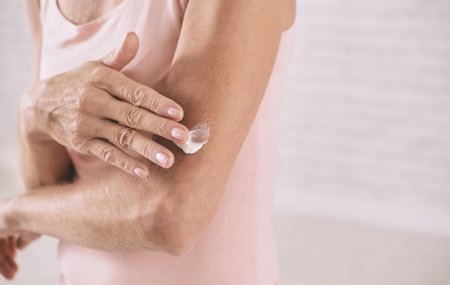 Woman applying lotion to arm