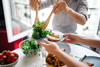 Image of two people plating up healthy food